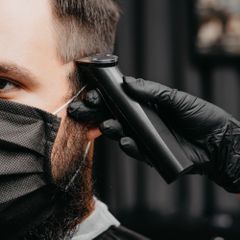 woman-barber-cutting-hair-to-bearded-man-in-face-mask-quarantine-hairc